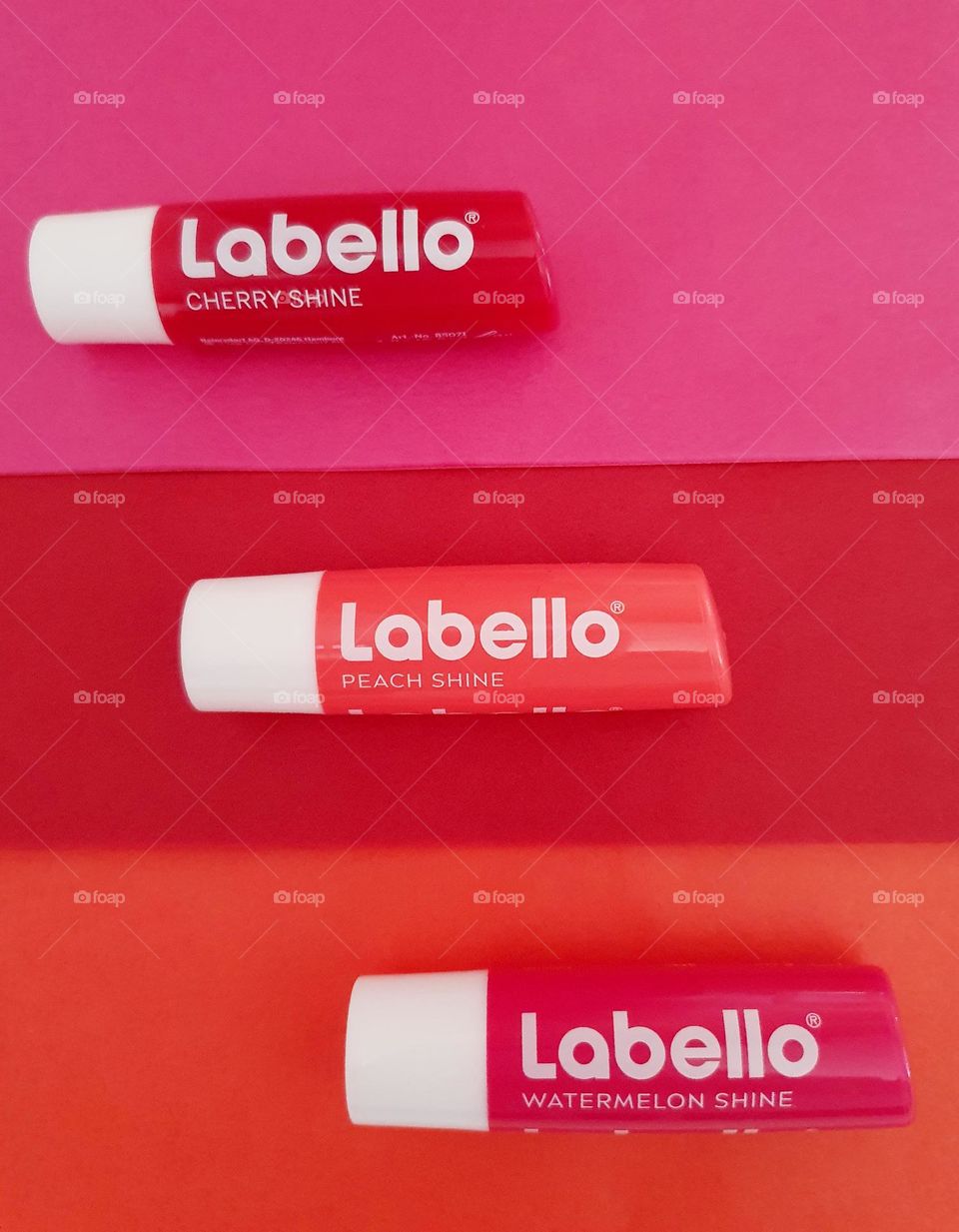 Labello Watermelon, cherry and peach shine flatlay on watermelon, cherry and peach paper surface