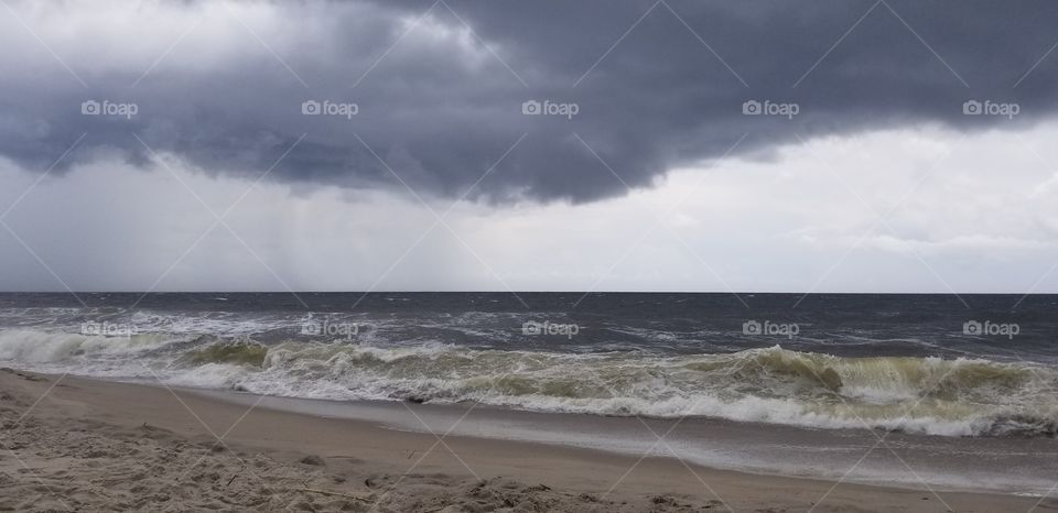 An approaching storm churns the waves to a dark and ominous atmosphere.