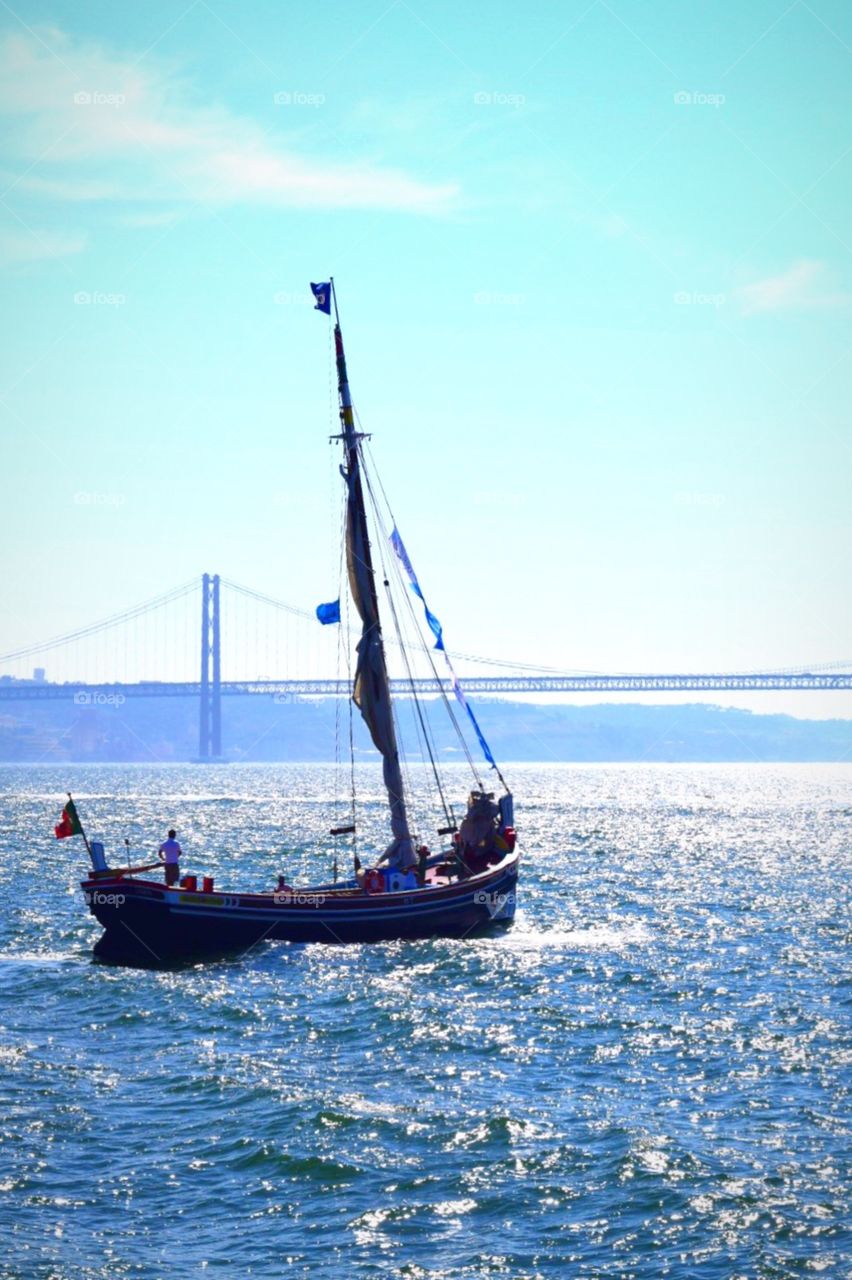 Boat and de 25  abril bridge in the background on taguus river in Portugal 