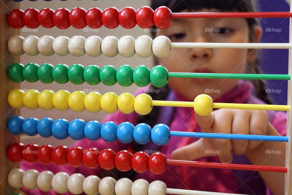 Young girl is playing with abacus