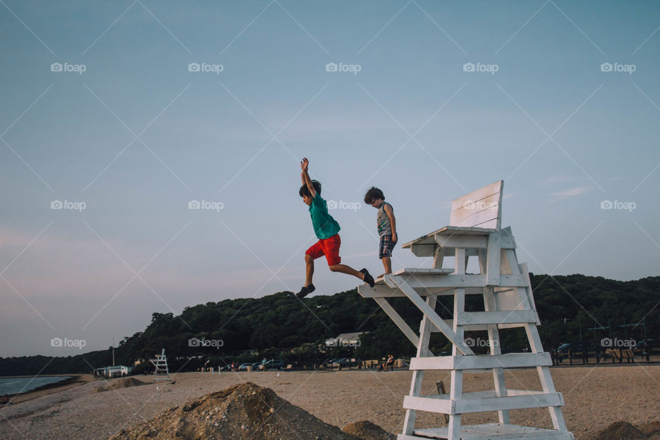 Kids jumping off lifeguard tower