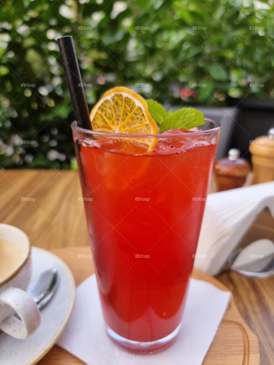 Cool glass of red, homemade lemonade,  outside on a hot day