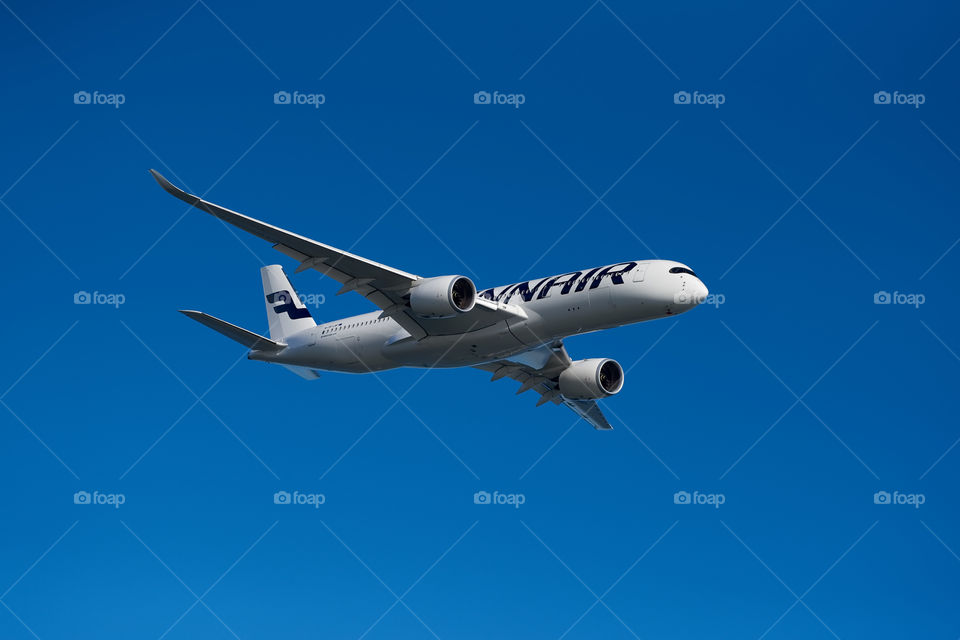 Helsinki, Finland - 9 June 2017: Finnair Airbus A350 XWB airliner flying on blue sky over Helsinki at the Kaivopuisto Air Show 2017.