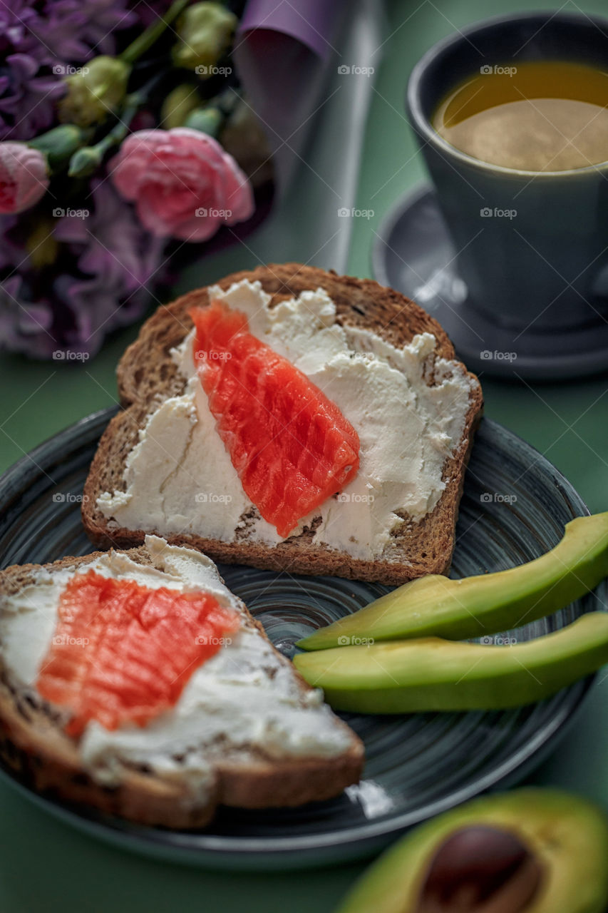 Breakfast with toast with cream cheese, red fish and avocado 