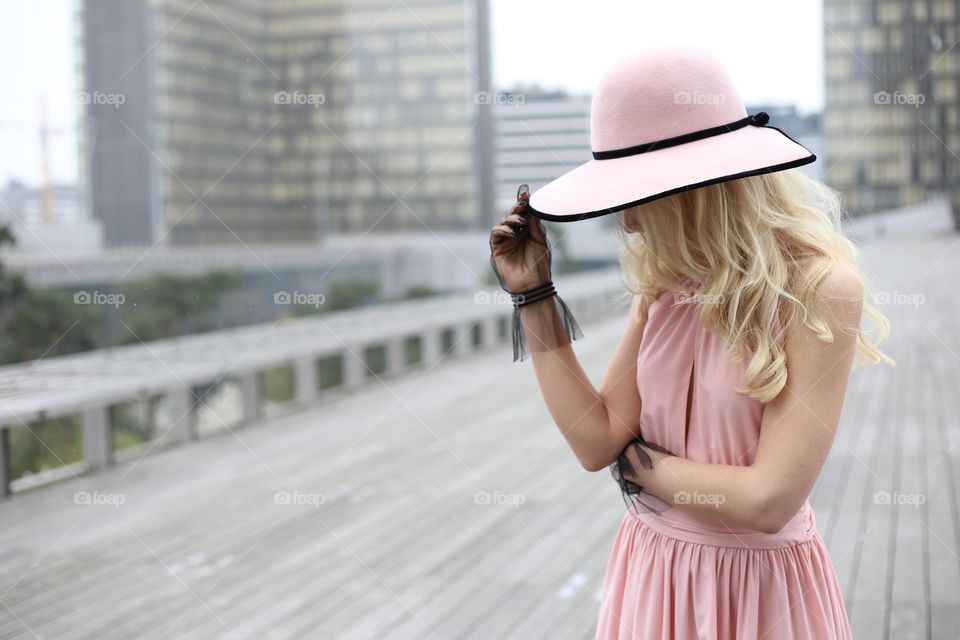 Faceless woman in pink hat and dress
