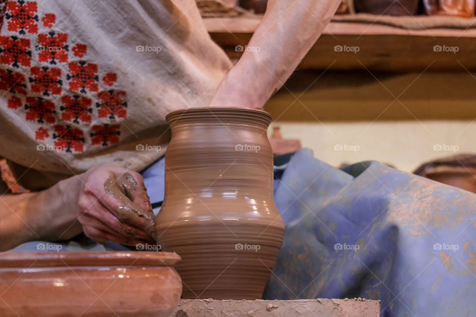 Learning pottery - man making a pot of clay