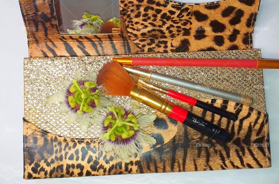 Beauty products with flowers - brushes, eyebrow pencil, and pencils