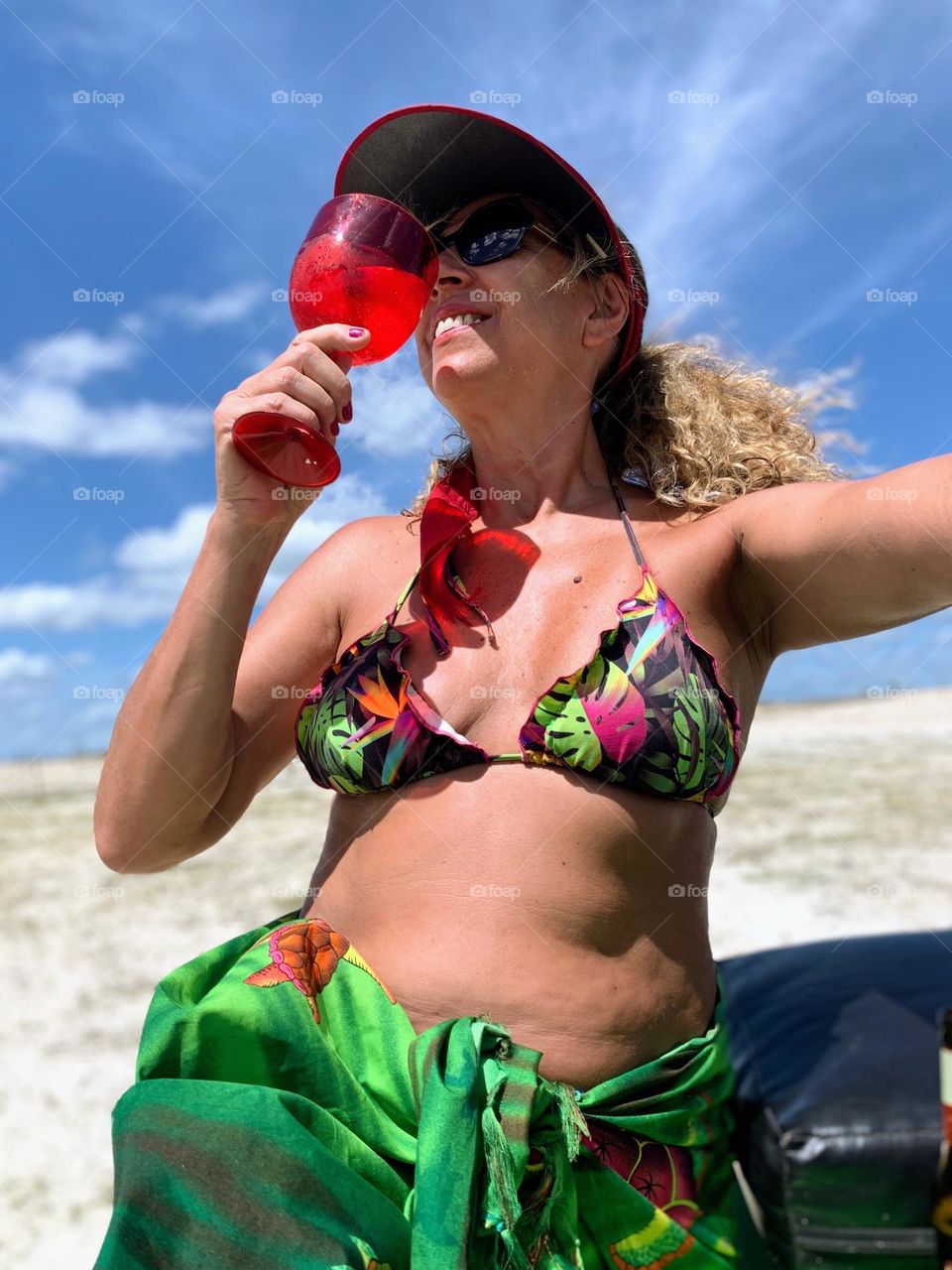 Woman feeling happy on the beach having a drink