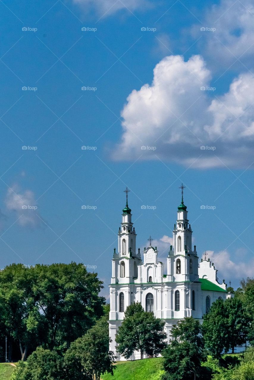 Cathedral on a green background under clouds