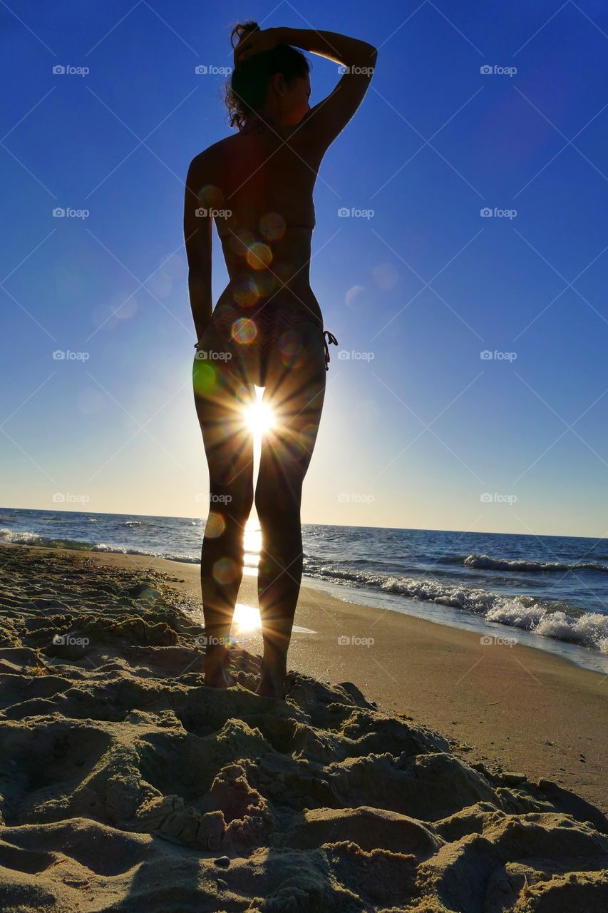Woman’s body in sunny rays