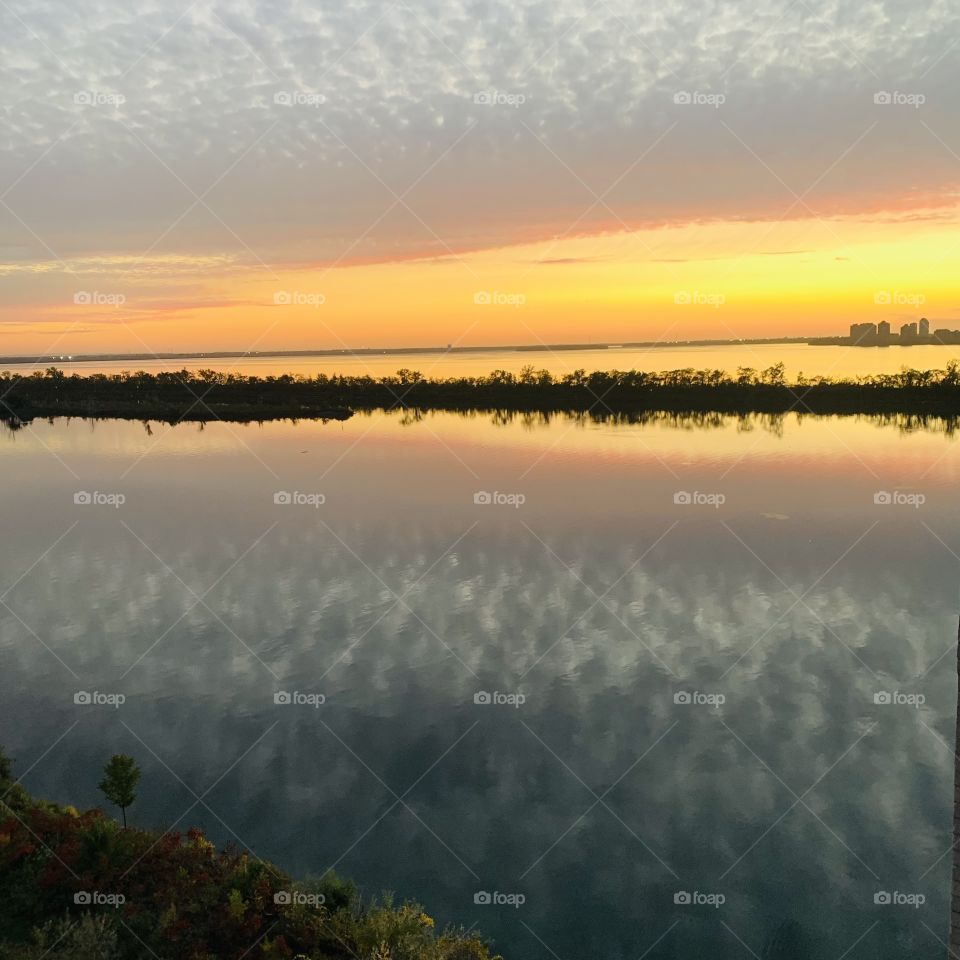 Mirror effect with a sunset and clouds on the St.Lawrence river, Quebec, Canada 🍁