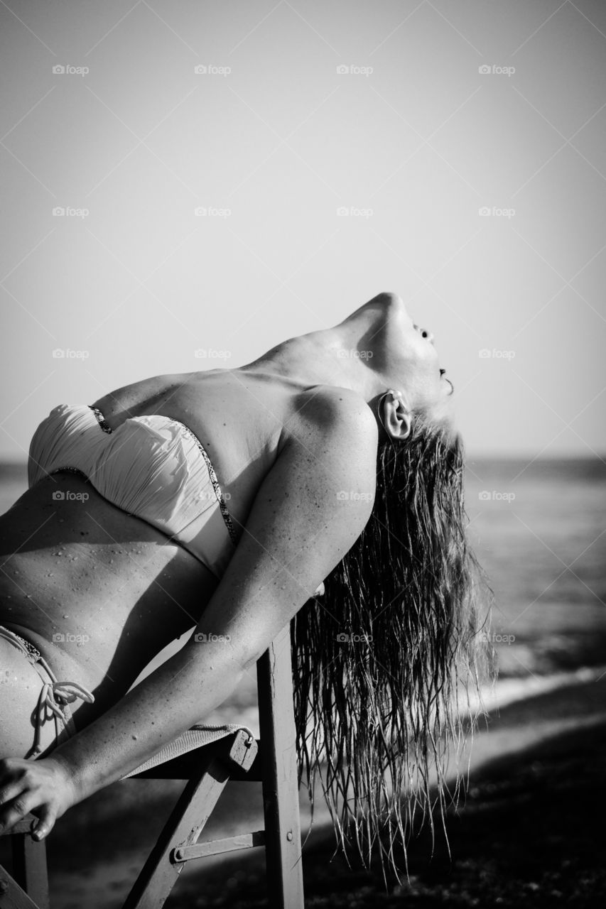 Close-up of a woman resting on chair at beach