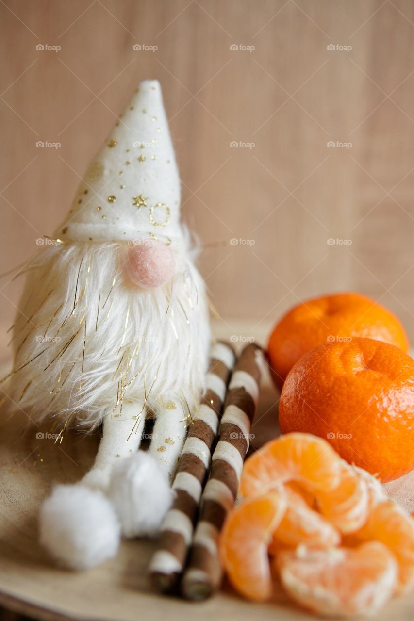 Christmas home decoration with leprechaun, cakes and tangerines.