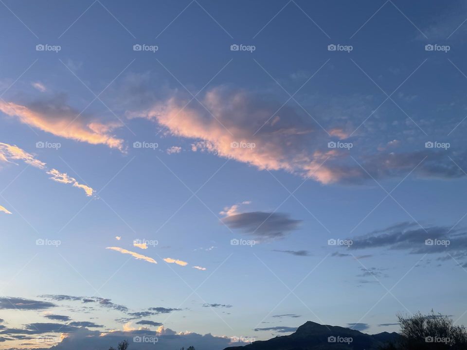 Pink clouds above a mountain.