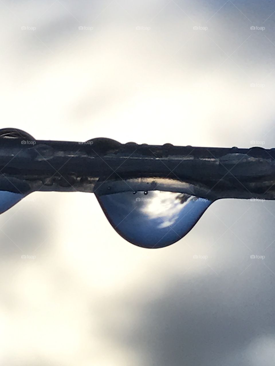 A water drop hangin on a washing line outside