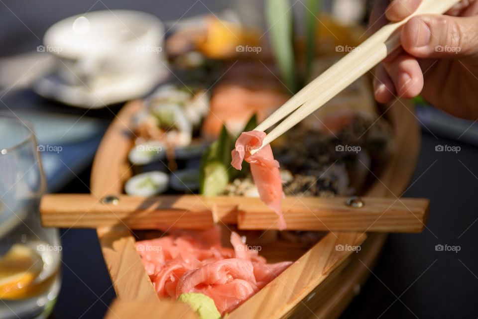 Set with spicy wasabi paste and pickled ginger on a wooden stand, top view. Maki and rolls with tuna, salmon, shrimp, crab and avocado.
