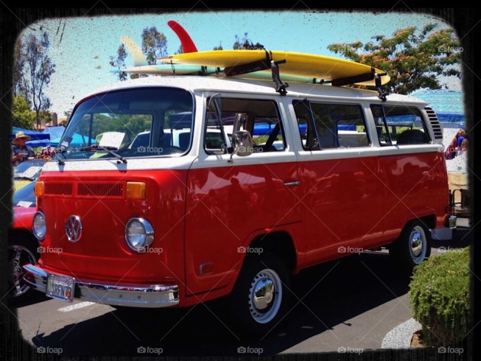 VW bus red with surfboard.