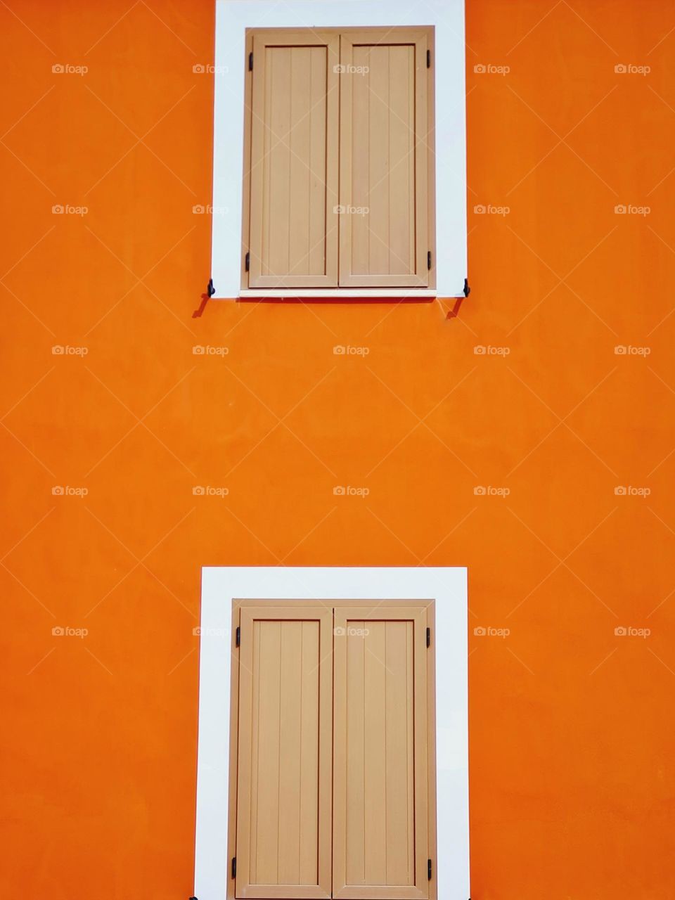 facade of an orange colored house with closed windows