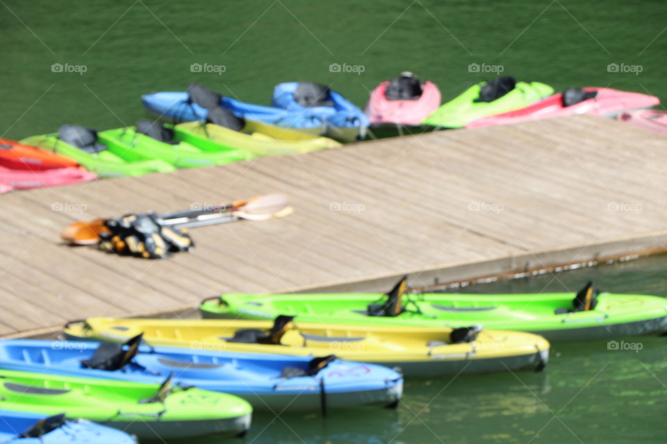 Colourful kayaks in green water