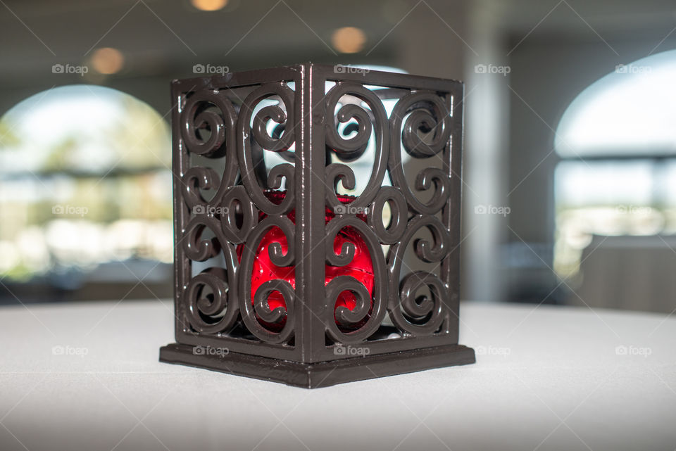 Black cast iron candle lantern with red candle holder inside