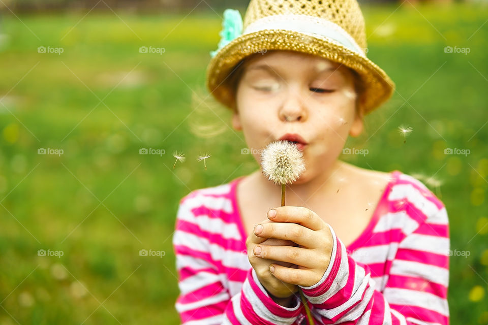 Girl is blowing on dandelion. Summer, good vibes