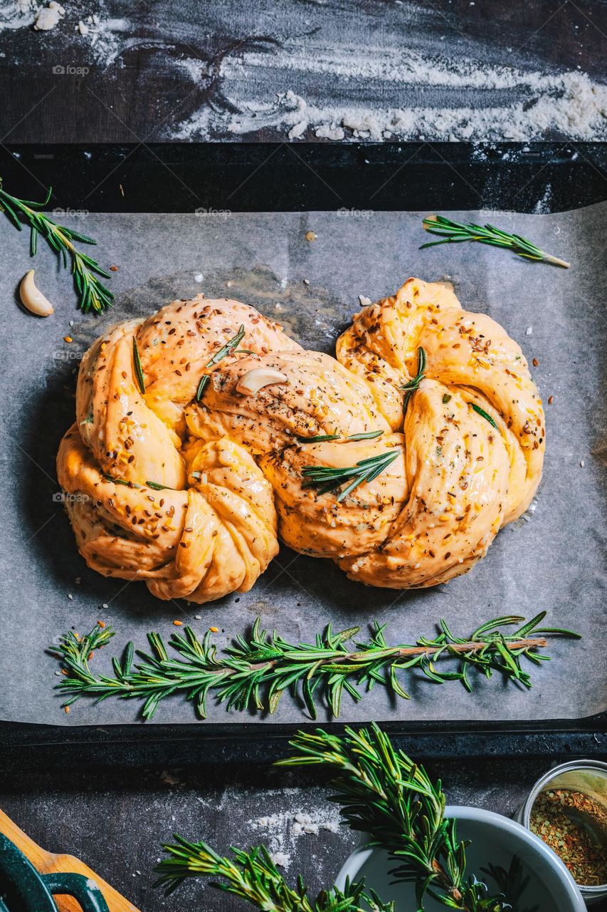 Women's hands, flour and dough. Levitation in a frame of dough and flour. A woman in an apron is preparing dough for home baking. Rustic style photo. Wooden table, wheat ears and flou.Emotional photo