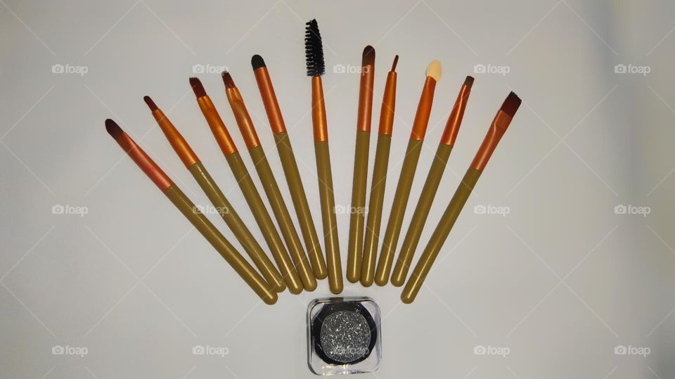 Beautiful arrangement of makeup brushes against a white background