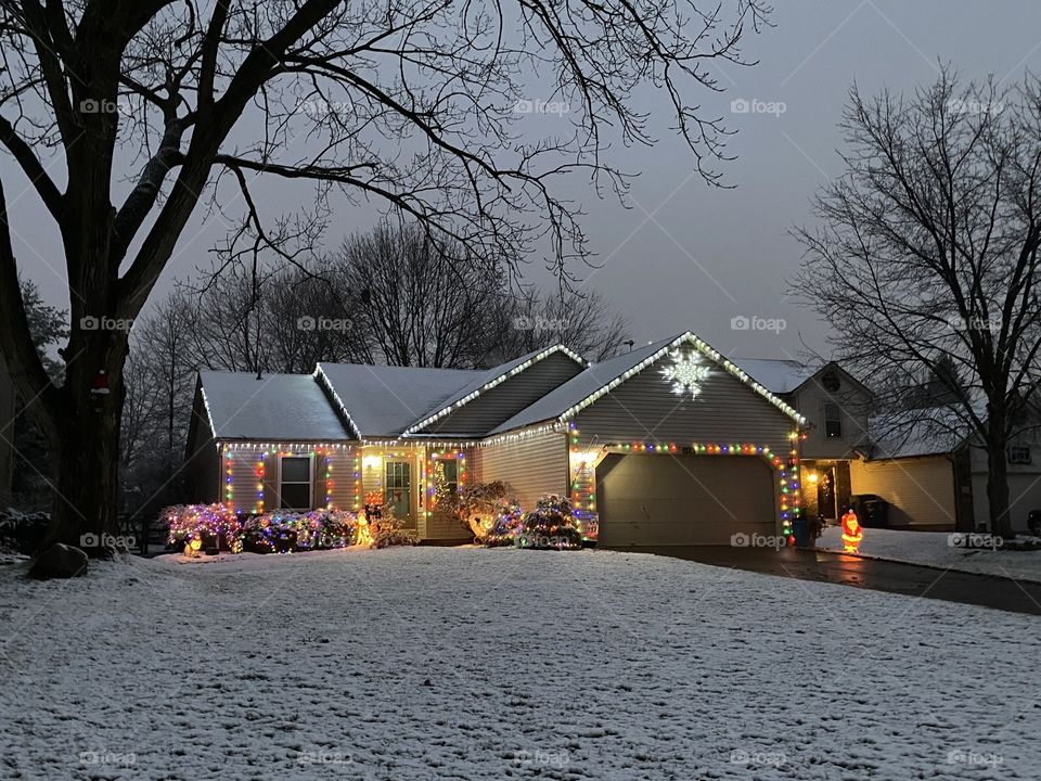 Cozy, snow covered home with Christmas lights.