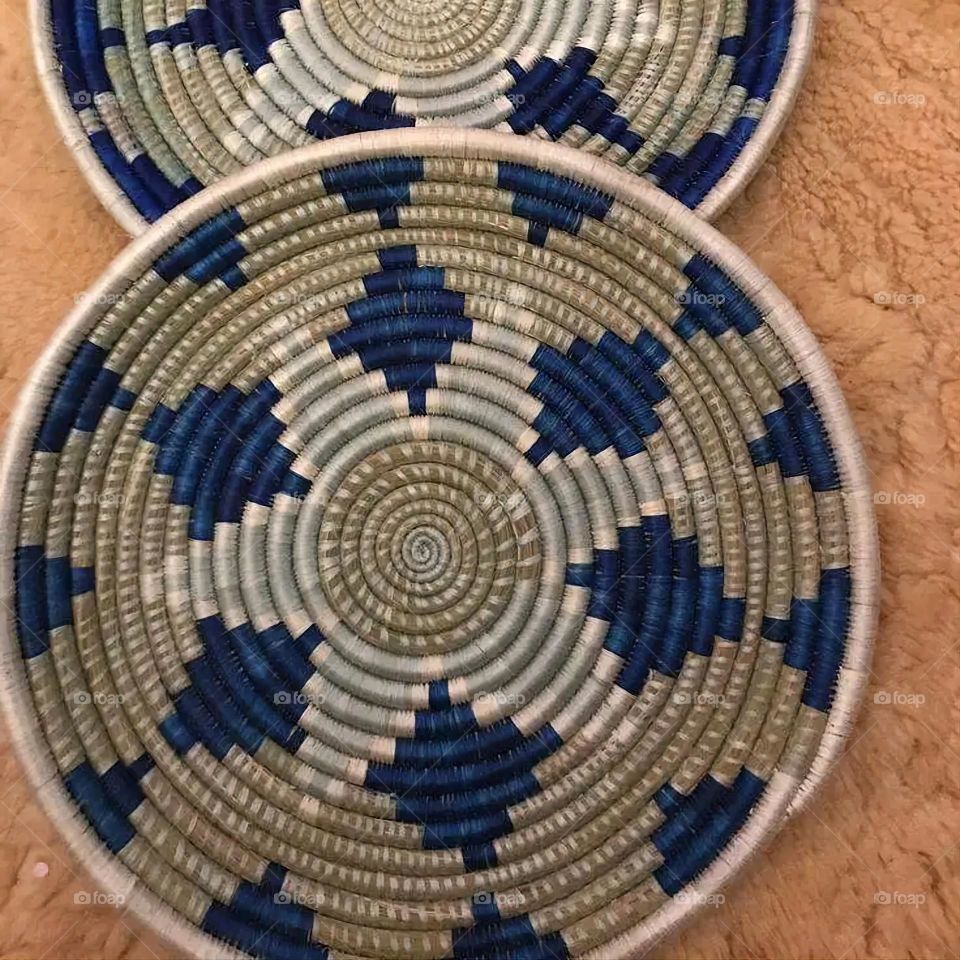 The image shows a group of hand -made dishes of wicker, decorated with colored embroideries with beautiful floral shapes, and is elegantly displayed in a warm corner that combines heritage and beauty, which gives the place an artistic spirit and attr