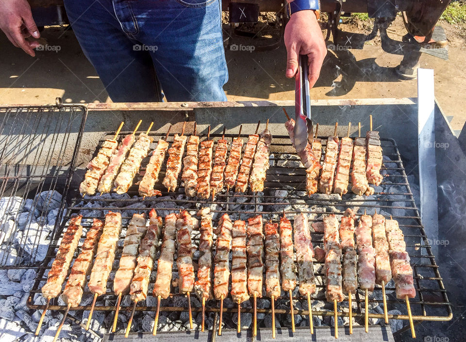 Man Roasting Barbecue On Grill Greek Souvlakia Pork Meat
