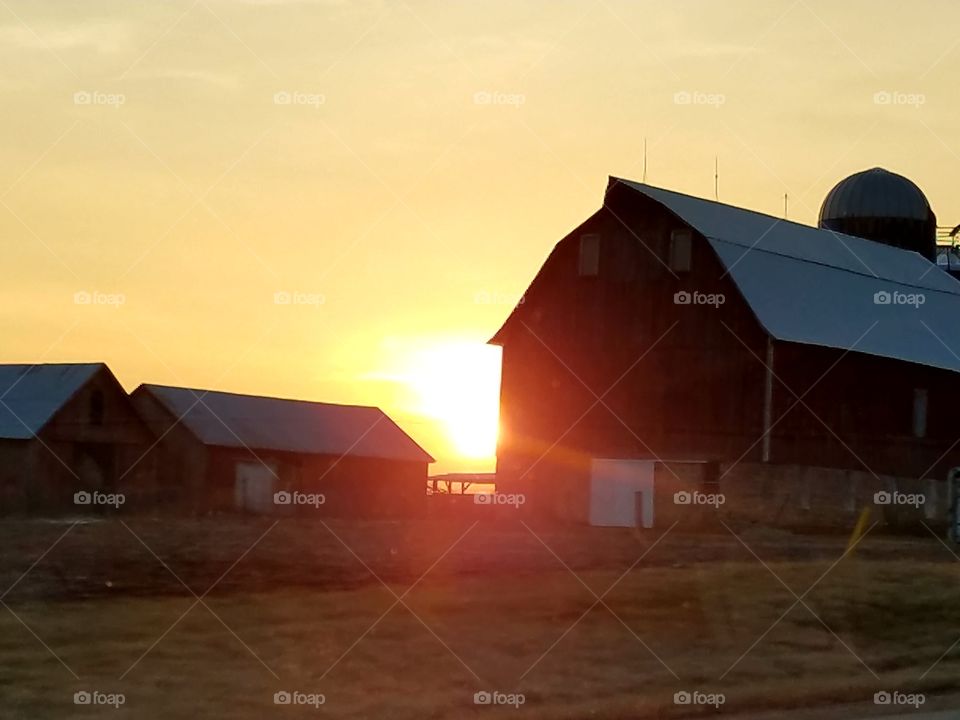 The sunset caught my eye, while we were driving back roads. It was beautiful shining behind the older buildings