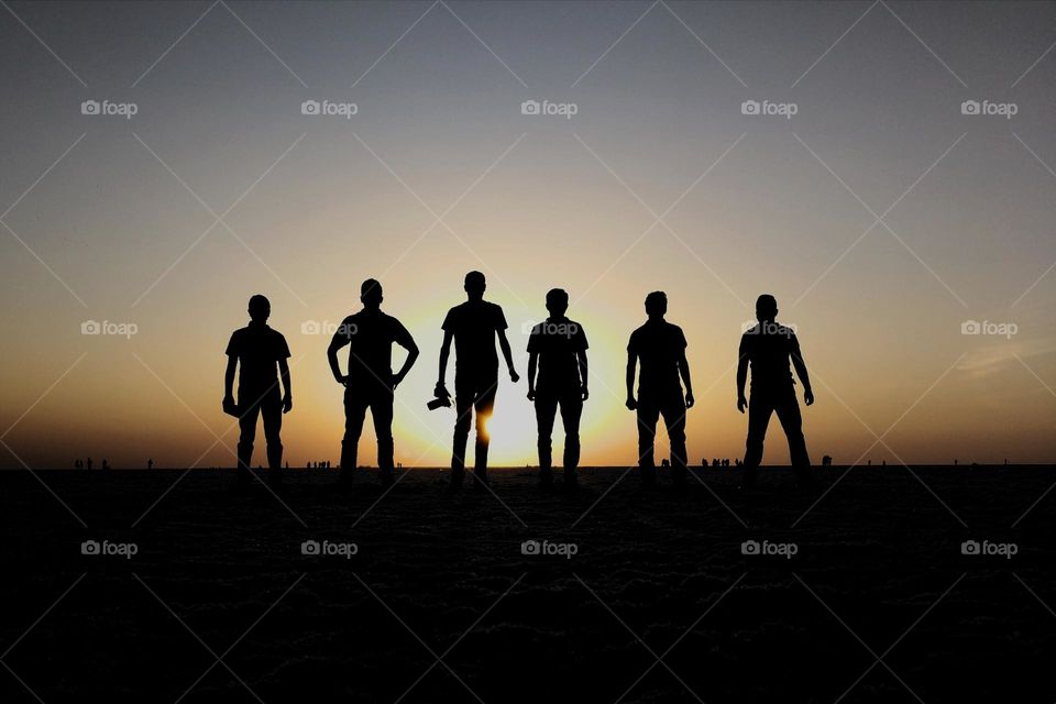 Silhouettes of Friendship: Bonding Under the White Desert's Evening Sky