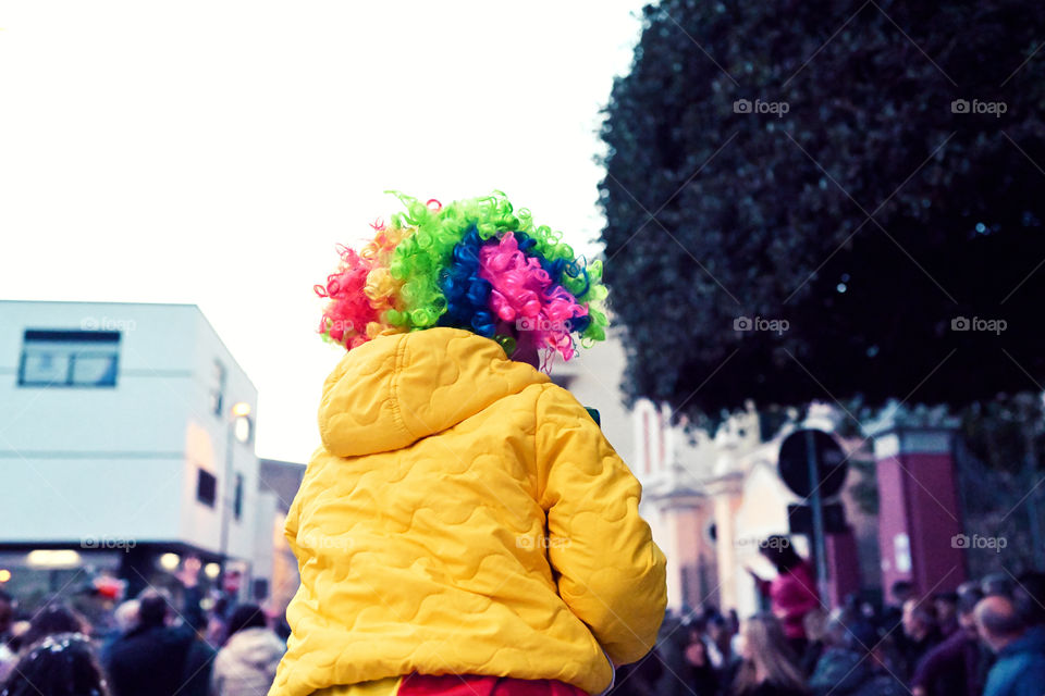 Child on father's shoulders celebrating carnival