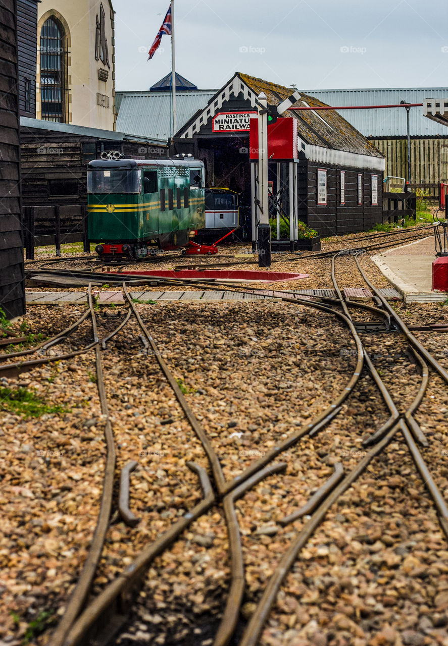 Small train tracks lead across the pebbles to Hastings Miniature Railway