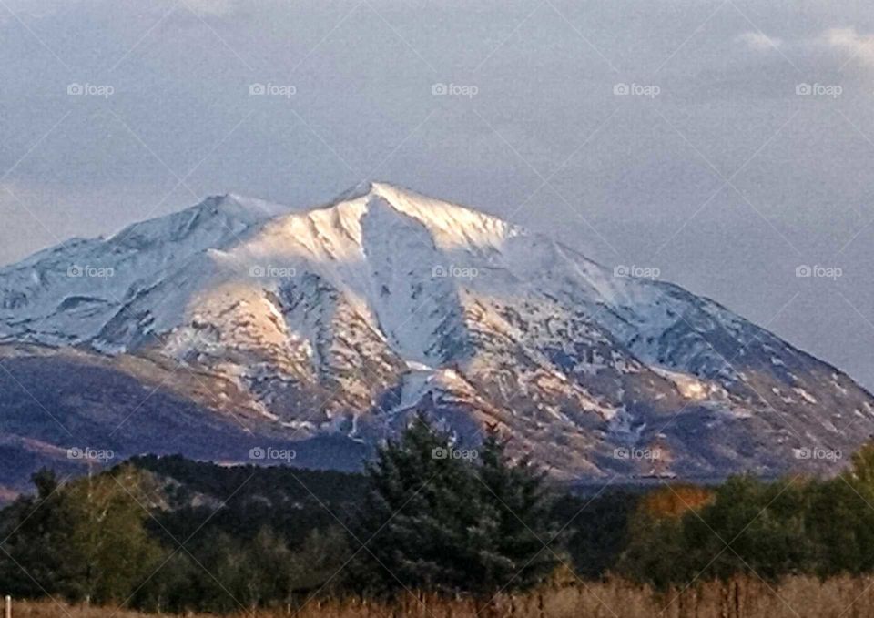 Mt. Sopris glowing white in a late evening sunset.