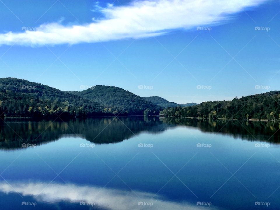 Forest and blue sky reflecting on lake