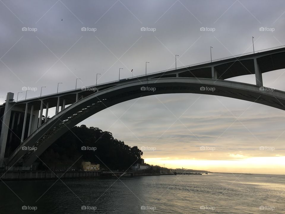 The Arrabida bridge in Oporto turning into a silhouette  as the sun goes down. 