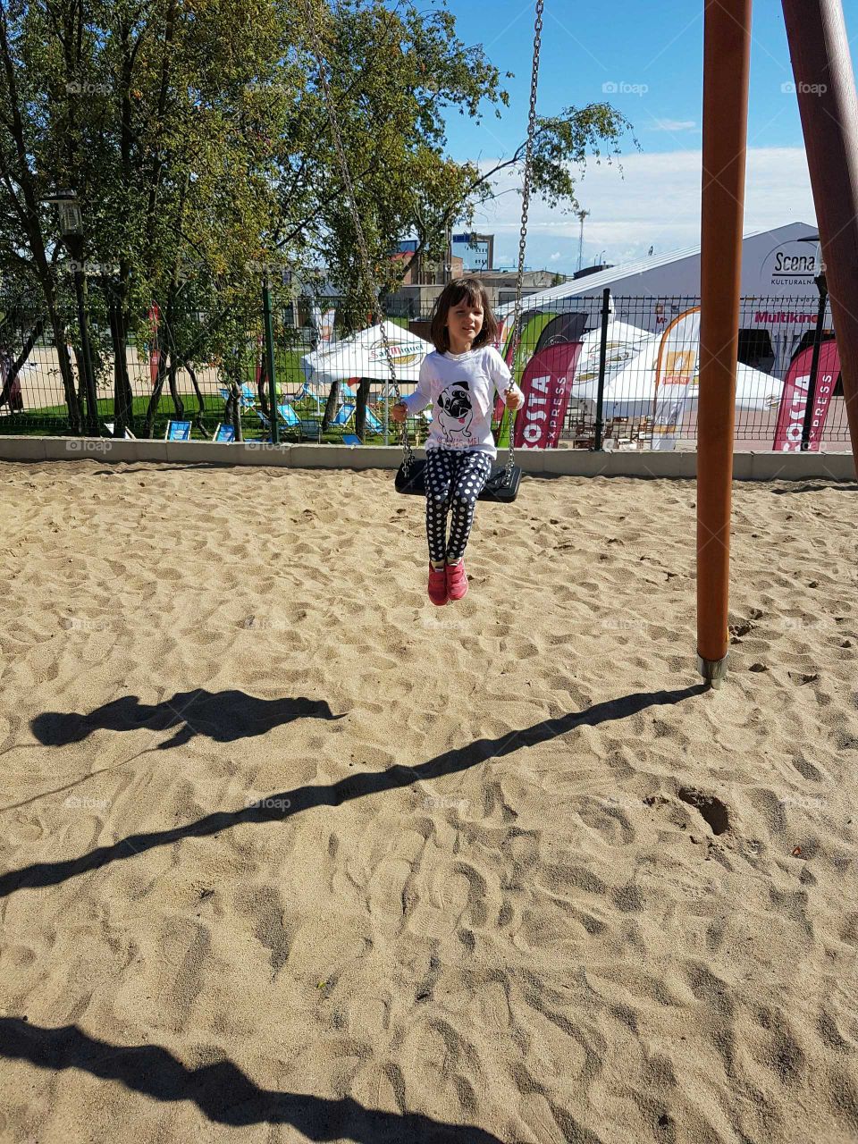 Girl having fun on swings at playground