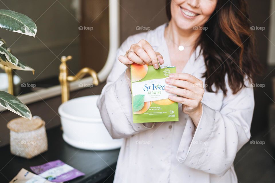 Young woman using sheet mask in hand 
