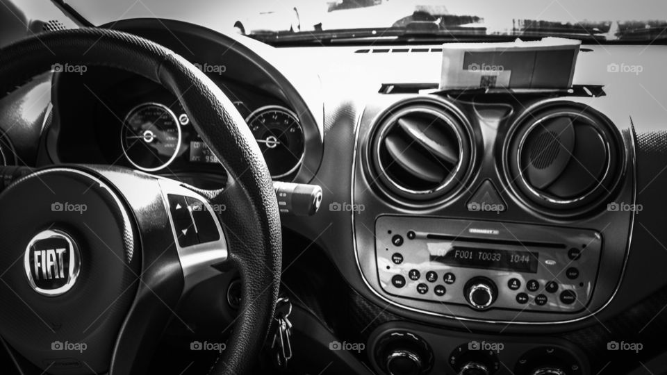 Carro em preto e branco. Painel, velocímetro, volante.