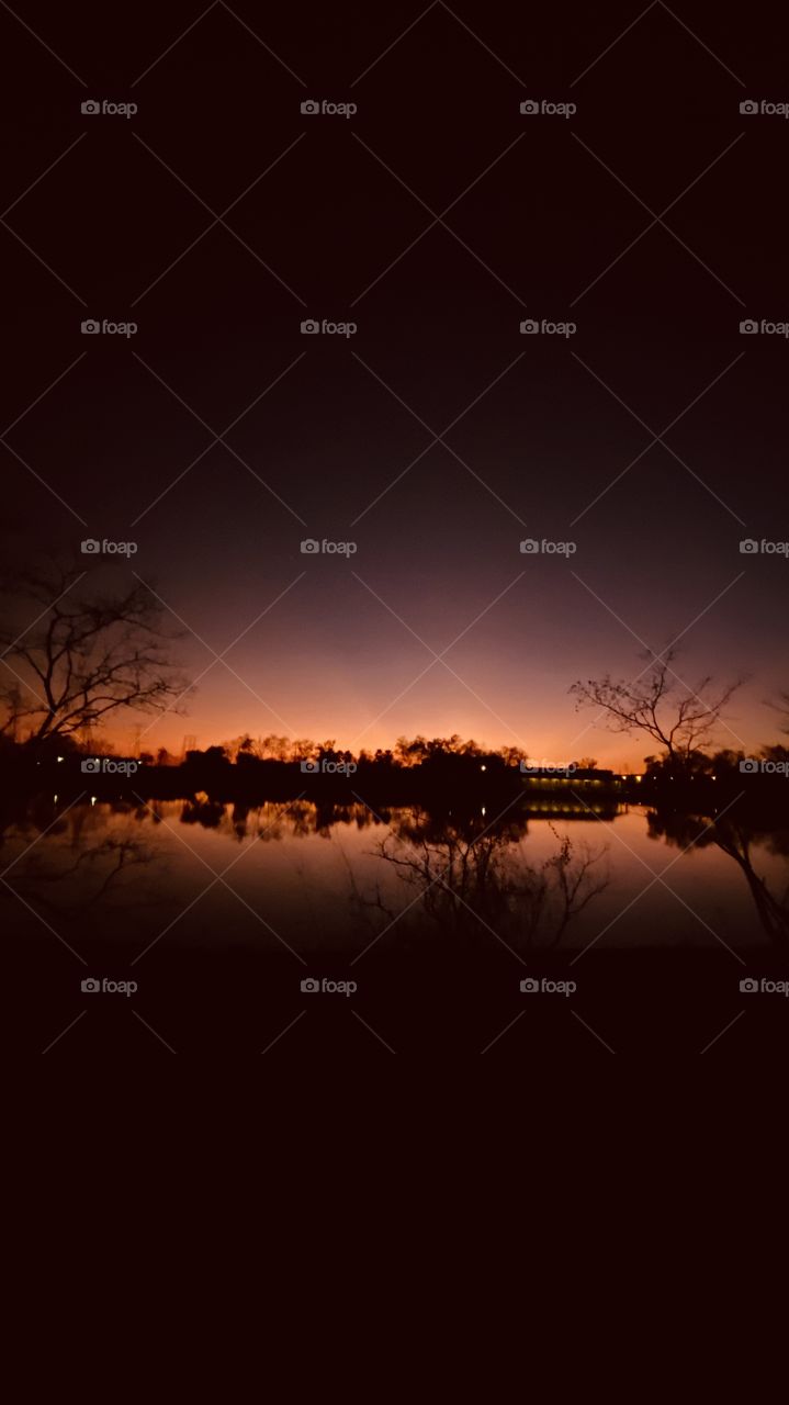 Reflections, mirrored image of Lake in beautiful colors. Above the night sky is moving in very close. Night is very near now. 
