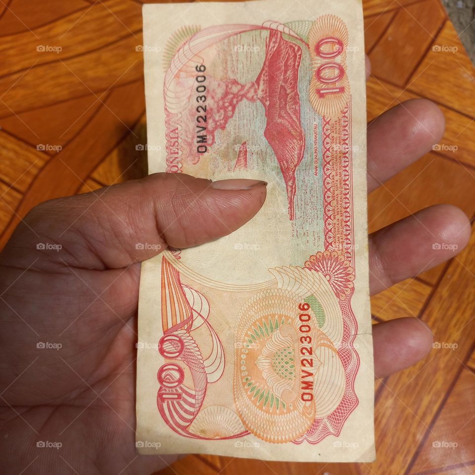 Old one hundred rupiah banknotes in hand
