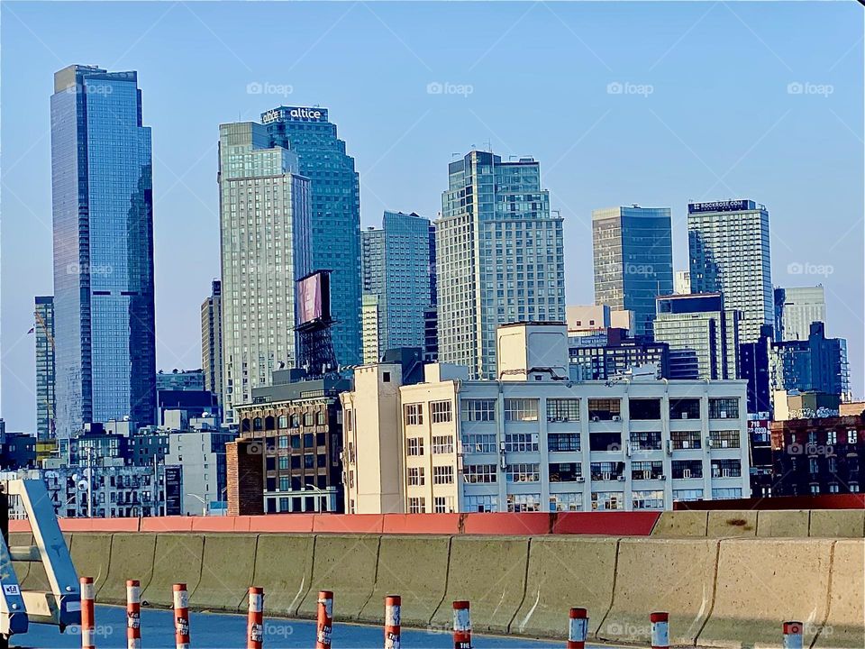This is a gorgeous evening time view of „Long Island City“, Queens with its own modern industrial style skyscrapers that are glowing beautifully in the light of the setting sun. 2023. Hypnotic Productions
