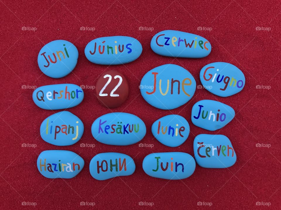 22 June, calendar date in many languages with colored stones and red background 