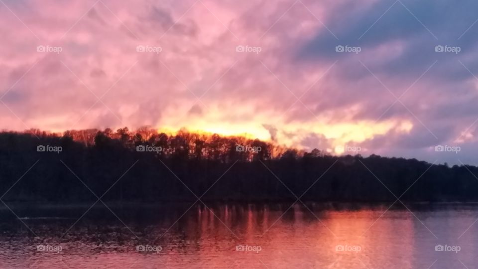 pink fiery sky over island during sunset.