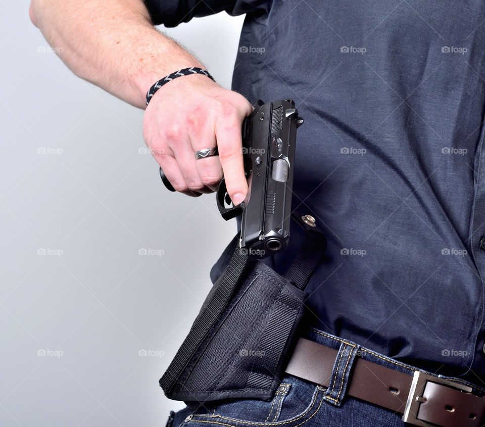 Man pulling out gun from holster
