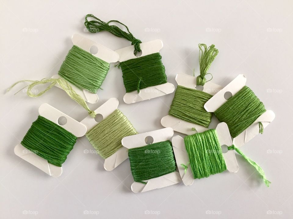 Green Color Story - flat lay of various shades of green embroidery floss / cross stitch thread on paper spools 