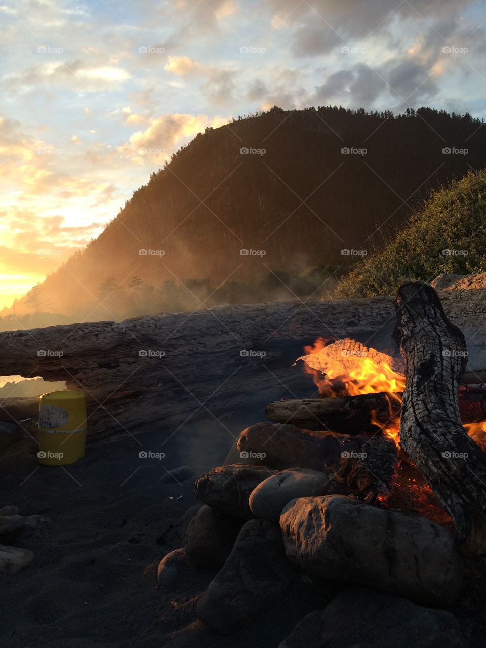 Camping and campfire in Northern California on the lost coast trail with mountains and a sunset 