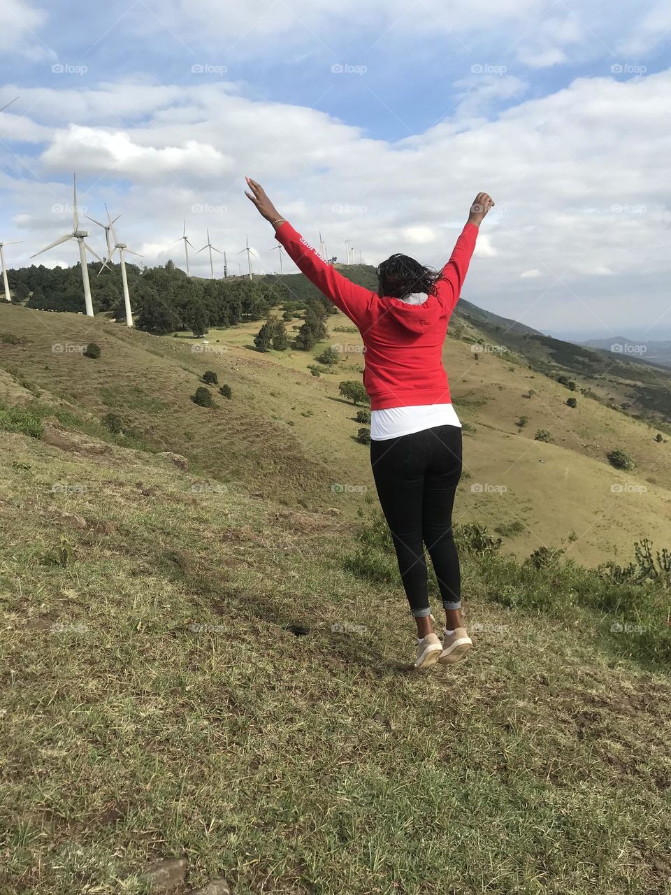 Cloud one person sky wind environment Nature full length Adult Windmill landscape mountain leisure activity day Land Jumping adventure Wind power beauty in Nature outdoors Wind Turbine in Ngong, Kenya