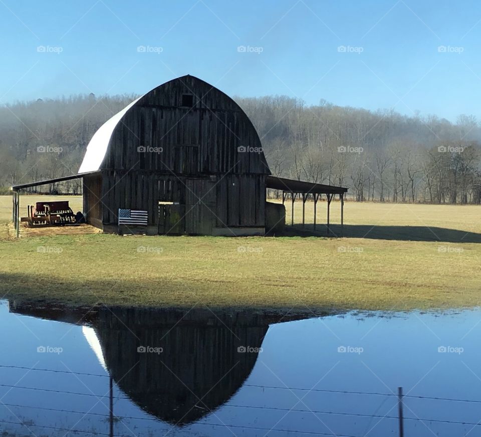 The glassy reflection of a beautiful old barn showing its patriotism in Arkansas. 